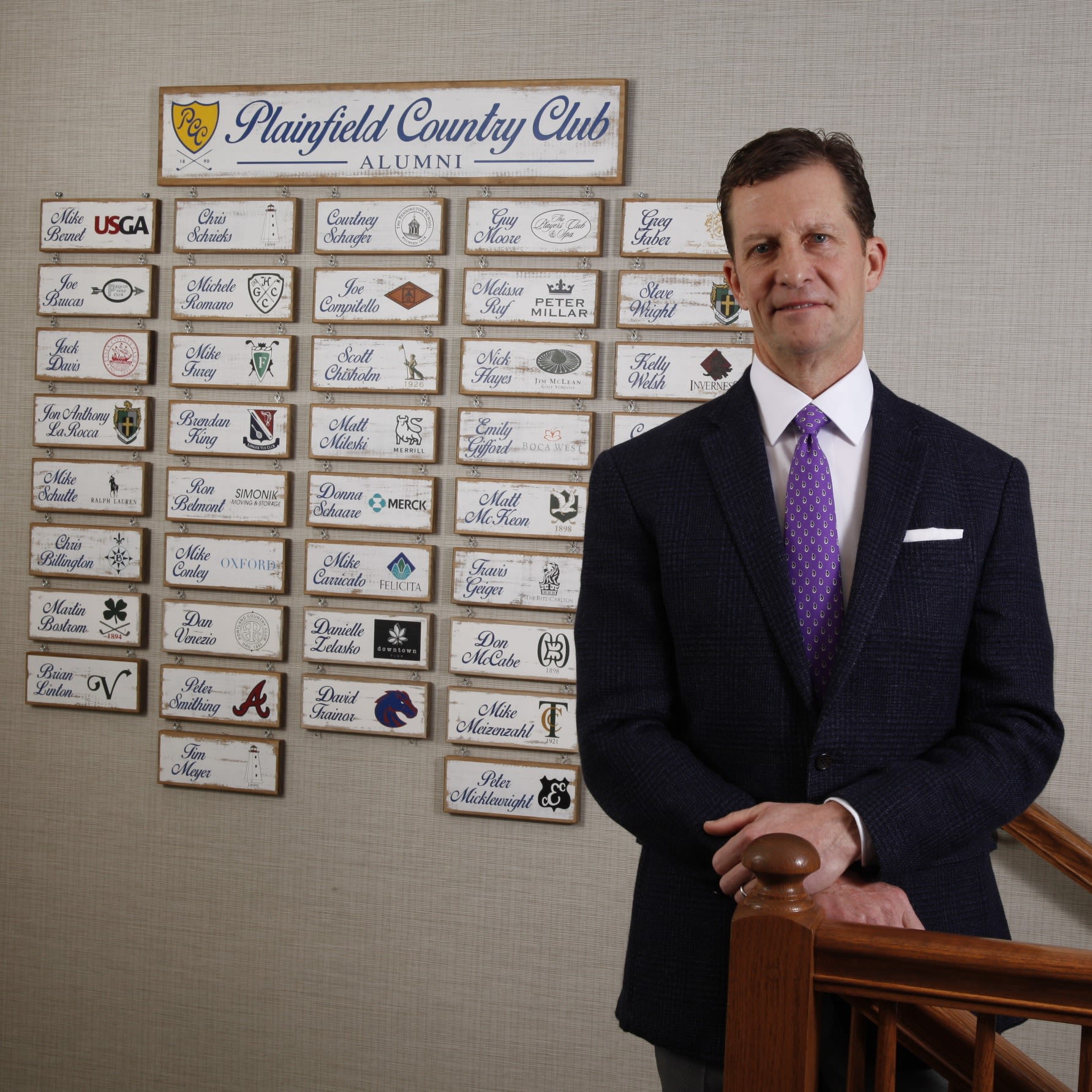 Paris stands next to the ever-growing Plainfield alumni wall.