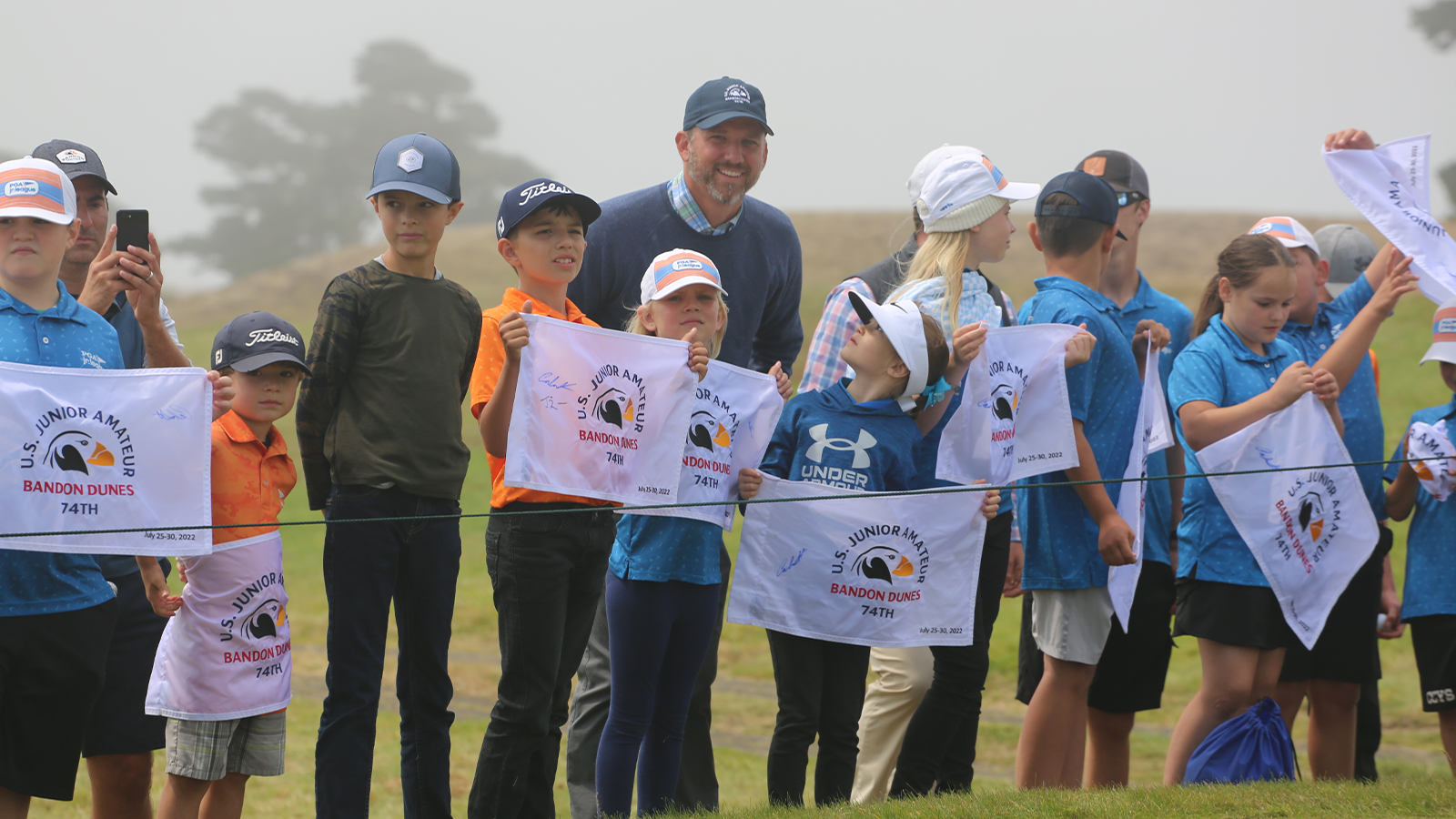 Bandon Dunes PGA Jr. League players show off their signed pin flags at the 2022 U.S. Junior Amateur.