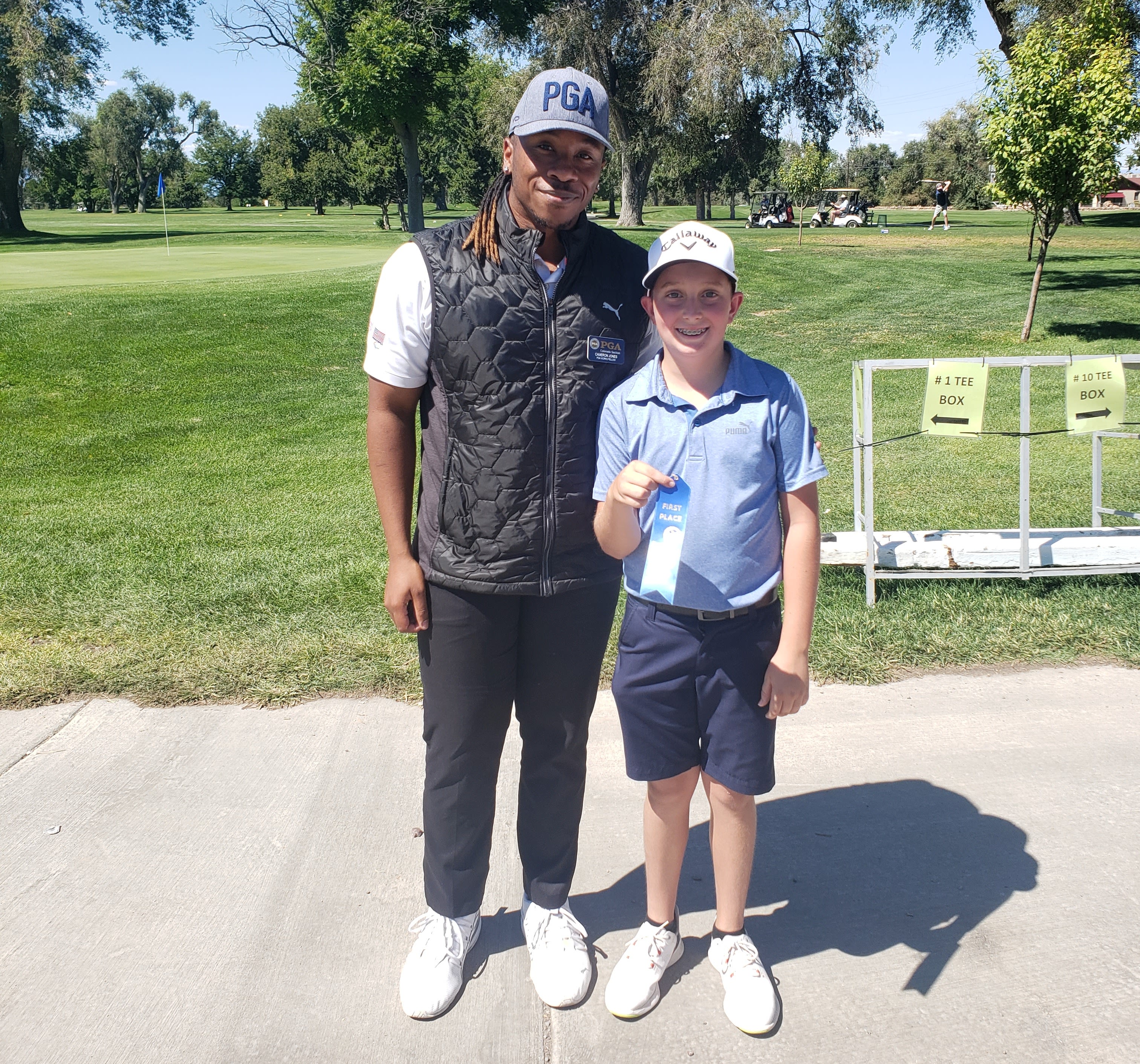 Cameron Jones with a Colorado PGA junior golfer during an event.