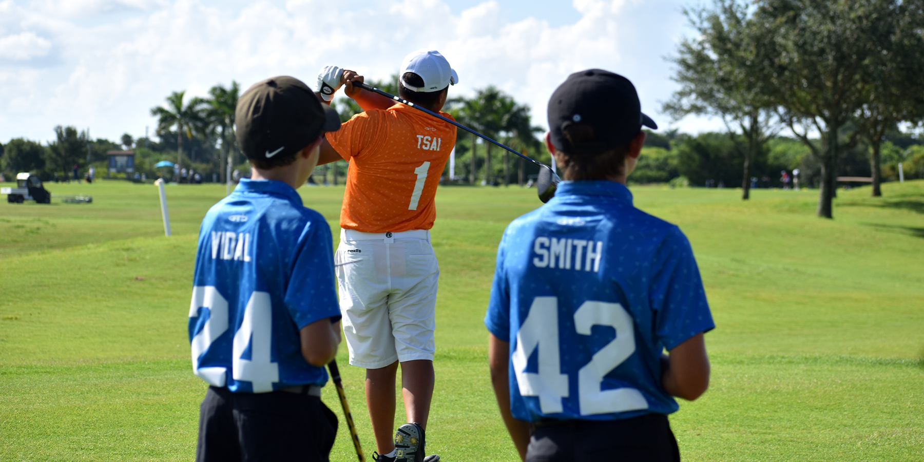 Competitors watch as a player hits a shot at the PGA Jr. League South Florida Section Championship. 