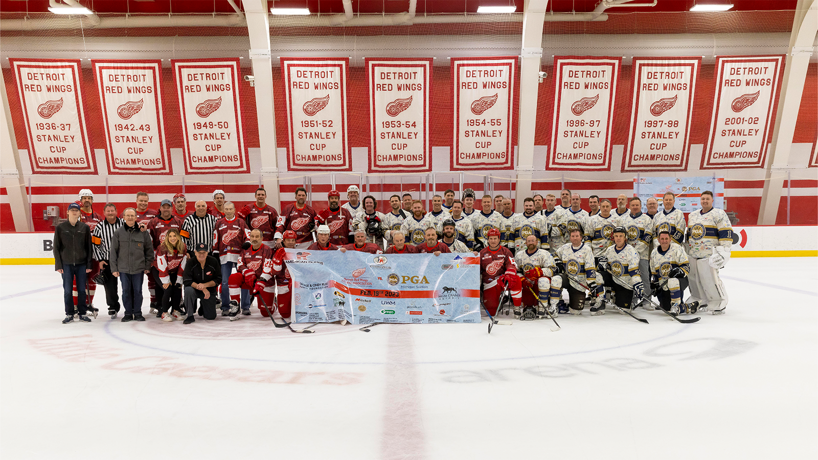 Players, coaches and representatives from the Michigan PGA and Detroit Red Wings Alumni Association pose for a post-game photo at BELFOR Training Center in Detroit.
