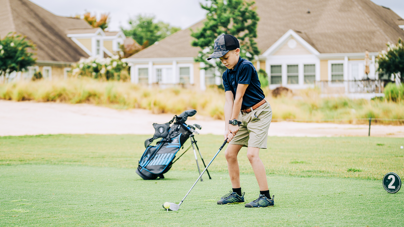 A child tees it up on the course. 