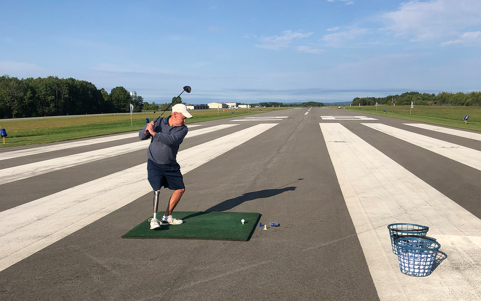A participant hits his drive down the runway. 