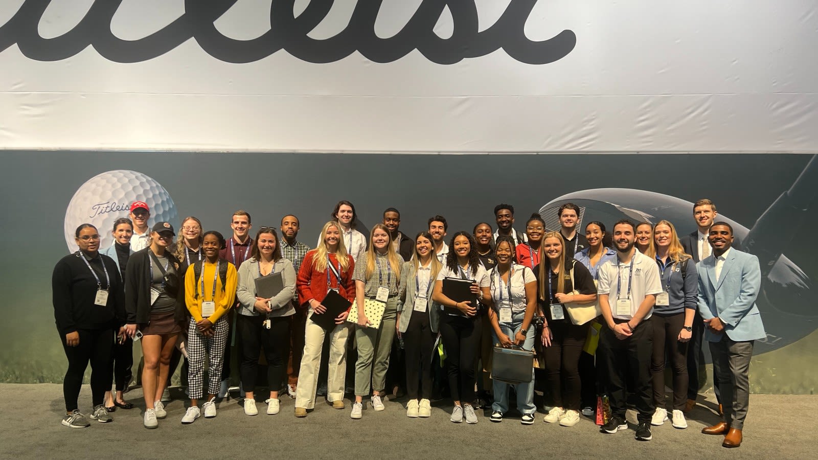 Attendees of the Career Exploration Day at the 2023 PGA Show pose in front of the Titleist exhibition.