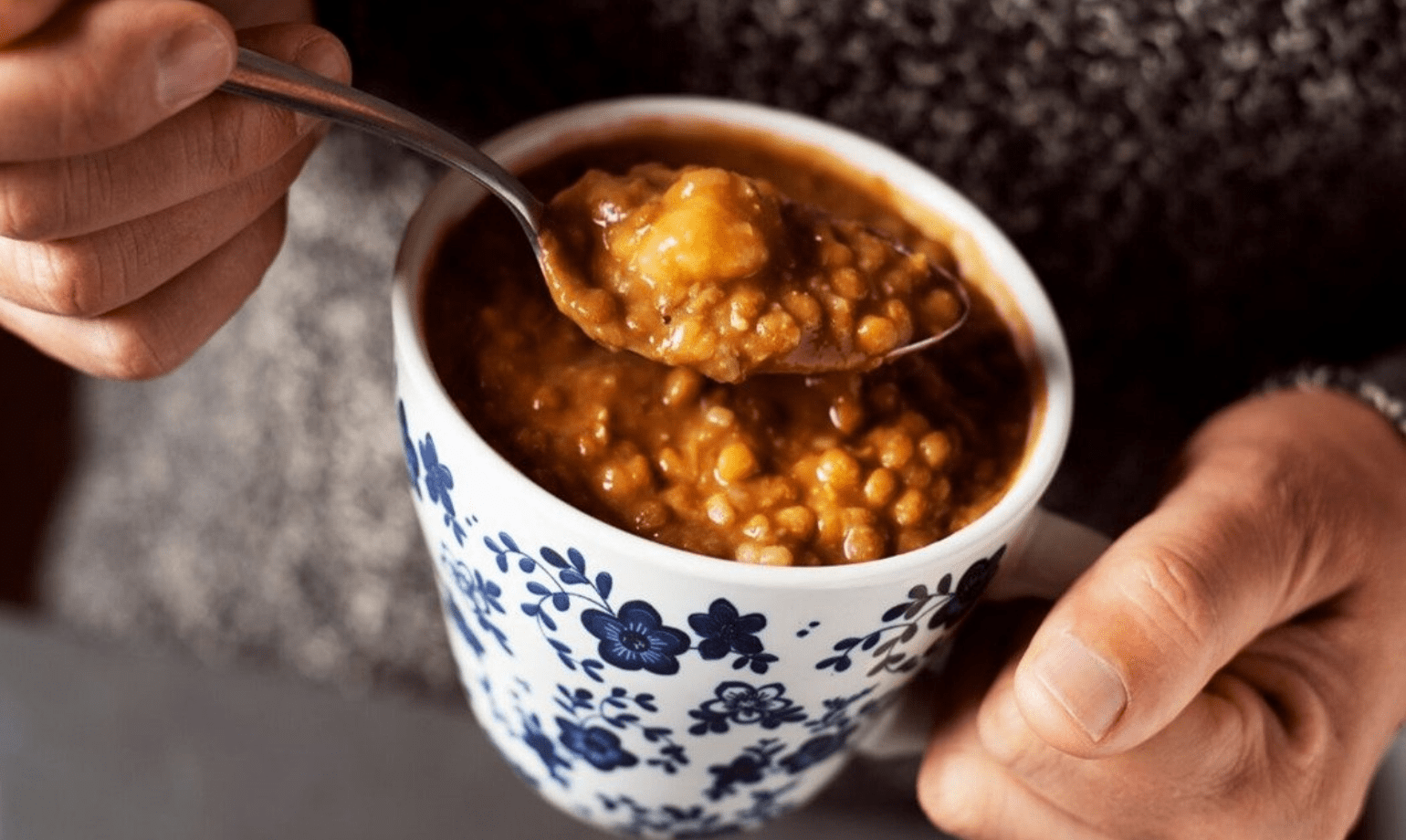 man eet zelfgemaakte soep uit een mok