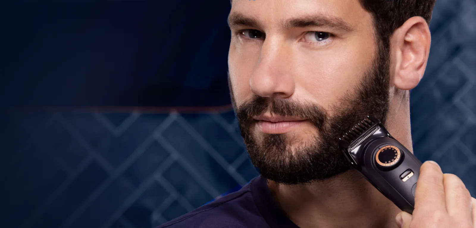 Homem a aparar a barba com máquina elétrica contra fundo azul escuro