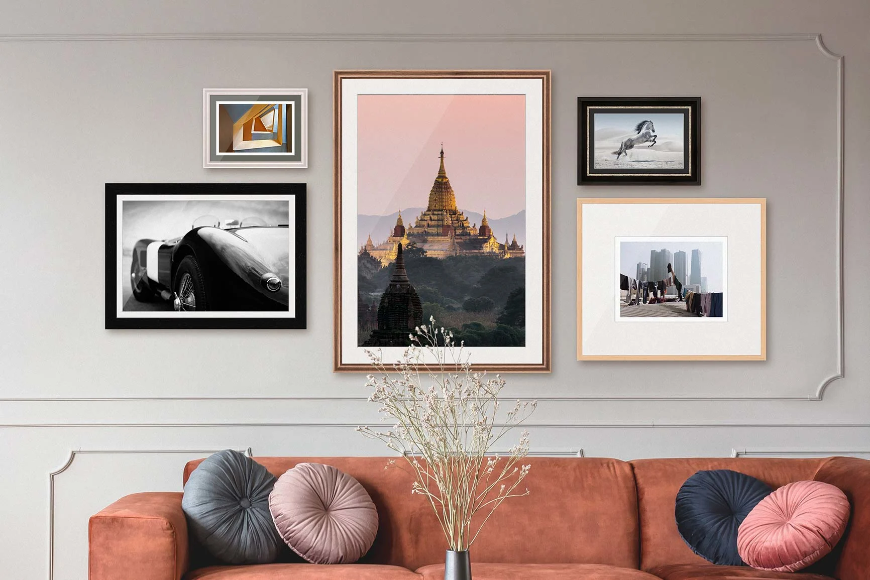 Verschiedene gerahmte Fotografien an einer Wand über einem Sofa.