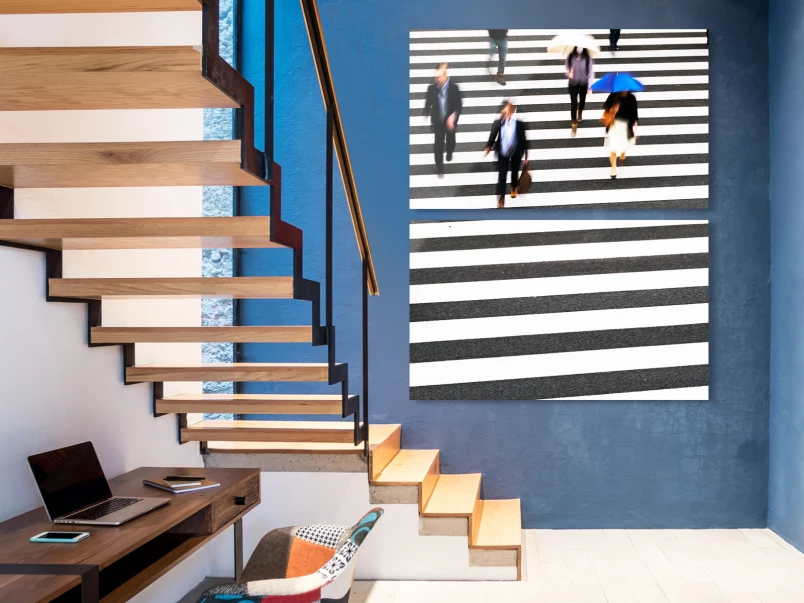 People walking across a crosswalk. The whole picture is divided into two parts hanging vertically on the wall. 