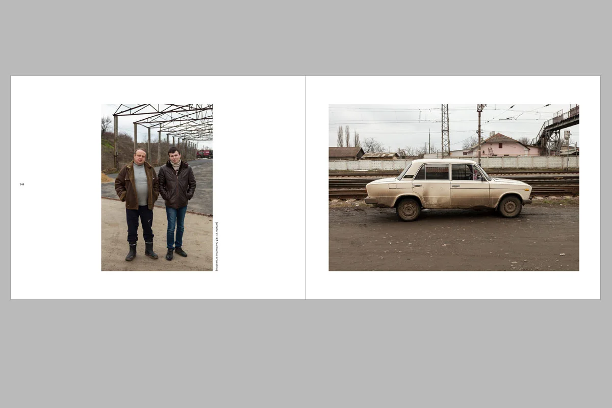 Opened photo book with two pictures: on the left two people, on the right an old car on a railroad track.