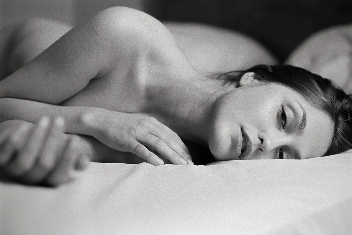 Portrait of woman lying on bed looking sensually at camera - photo by Jan Scholz.