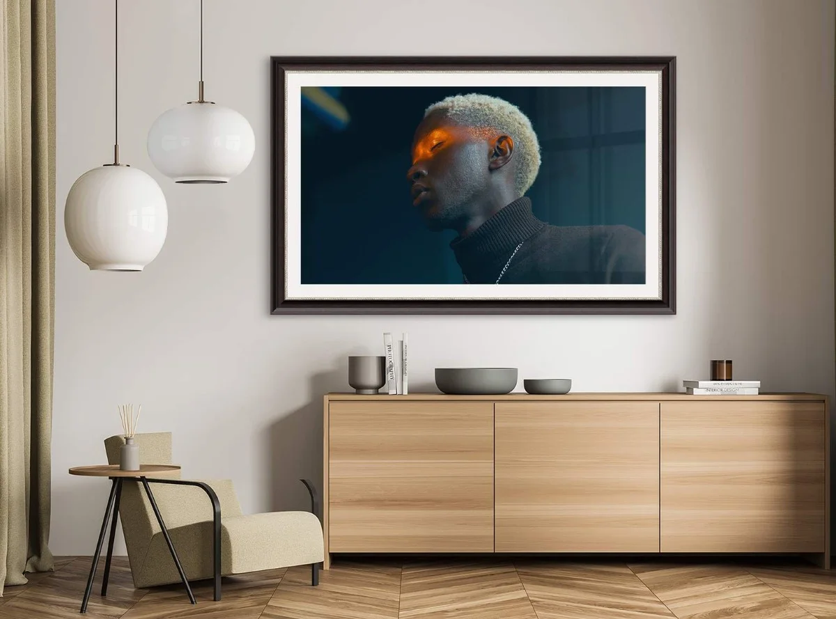 Ein moderner Wohnraum mit einem großen gerahmten Bild einer Person an der Wand hängend.