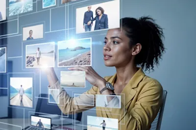 Woman in yellow blazer operates virtual screens with various photo thumbnails.