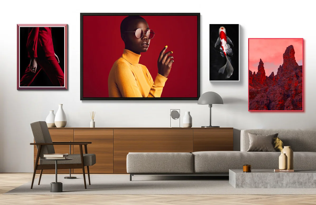 A living room with a modern design. A wooden sideboard with decorative objects stands in front of a white wall. Four pictures in different colors and sizes hang on the wall.