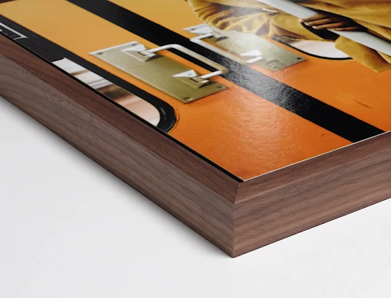 Fine Art Print auf Aluminium Dibond mit Holzrahmen, Detailansicht der Kante und eines Teils des Motivs mit orangefarbenen und schwarzen Flächen.