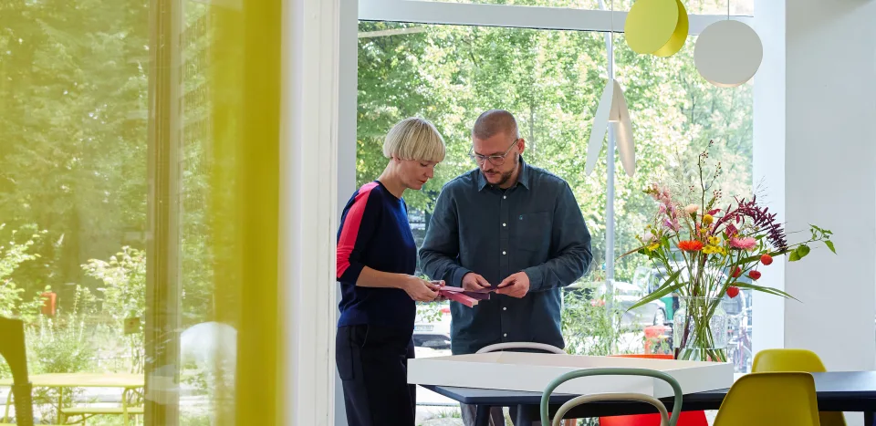 The designers at work, standing at a table