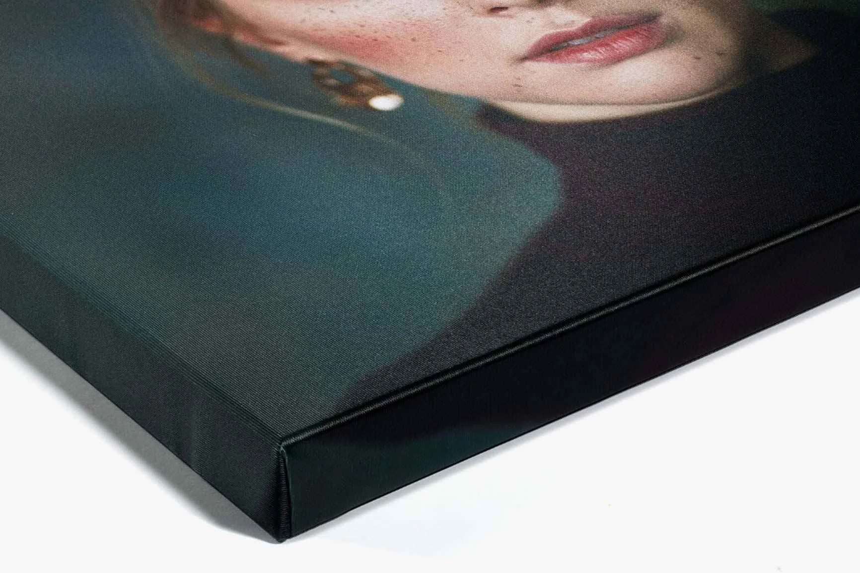 Primo piano di una tela con il ritratto di una donna che indossa orecchini e un maglione nero a collo alto.