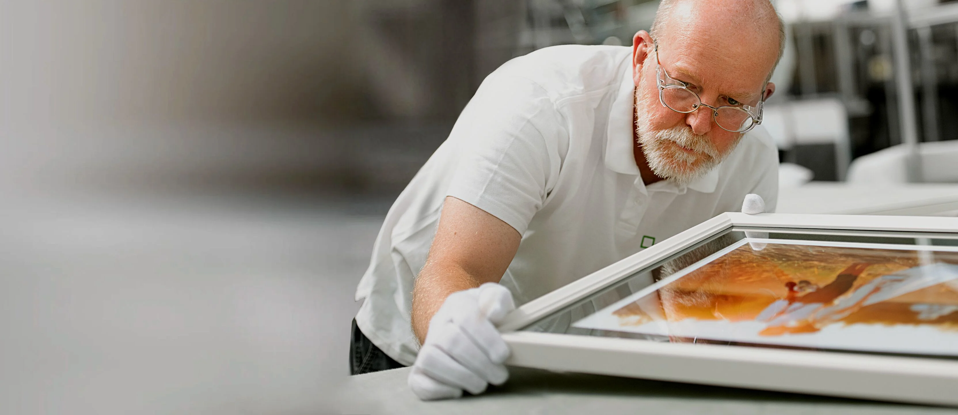 An employee in the White Wall Photo Lab examines a framed picture.