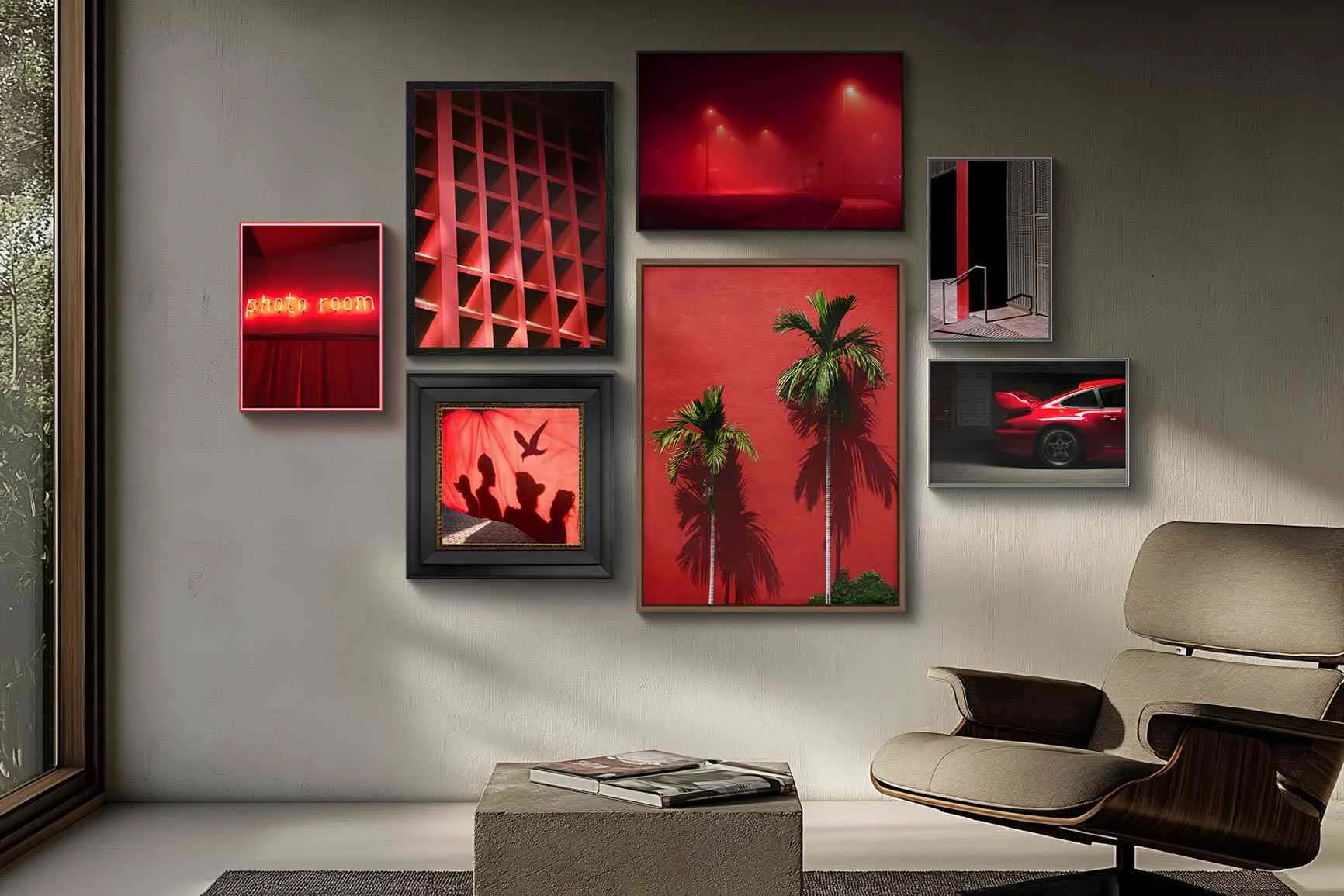 Parete con diverse immagini incorniciate, tra cui palme, un'auto e motivi astratti, tutti nei toni del rosso.