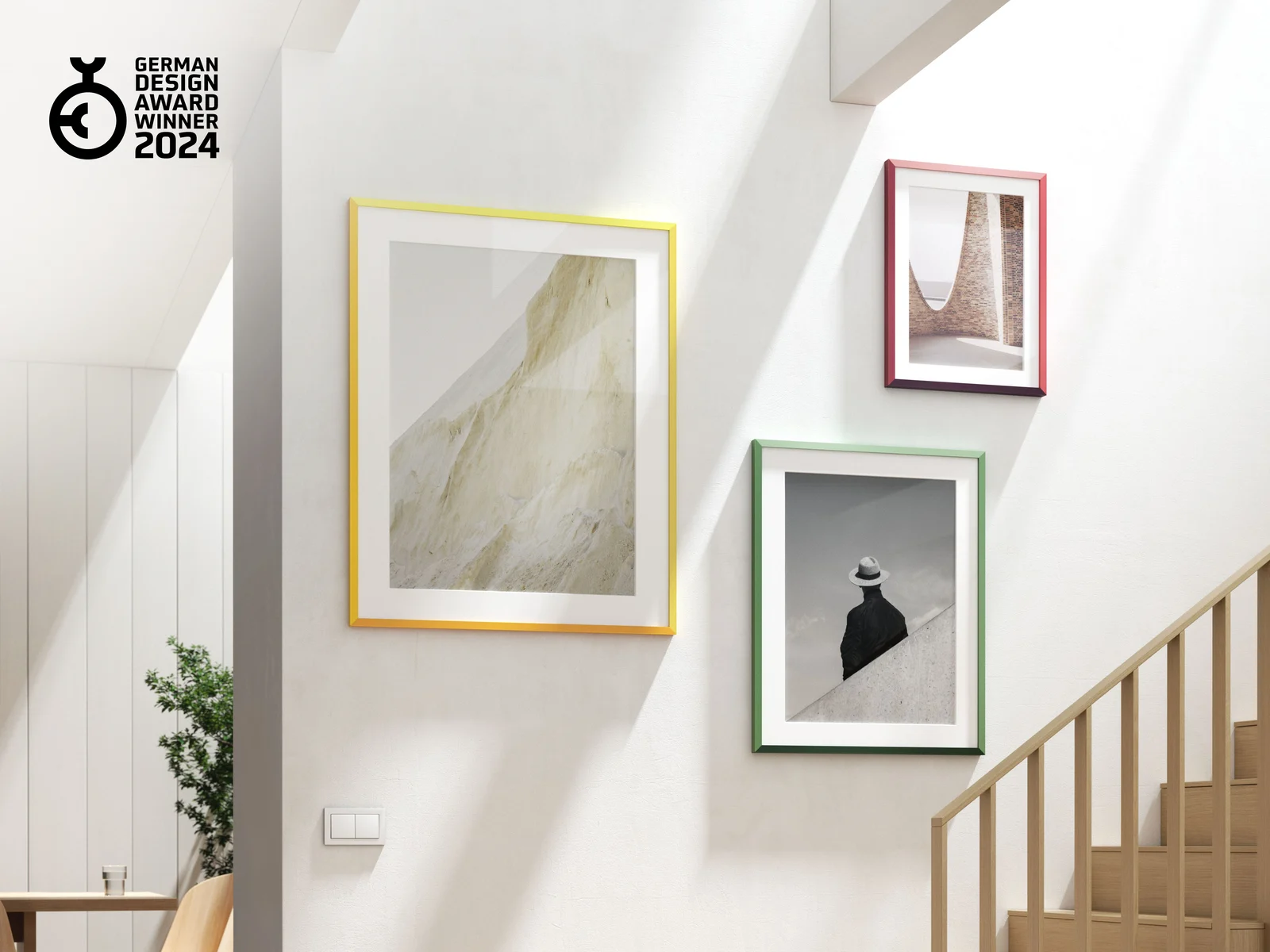 Three design edition frames, one of each color, hanging on a wall.