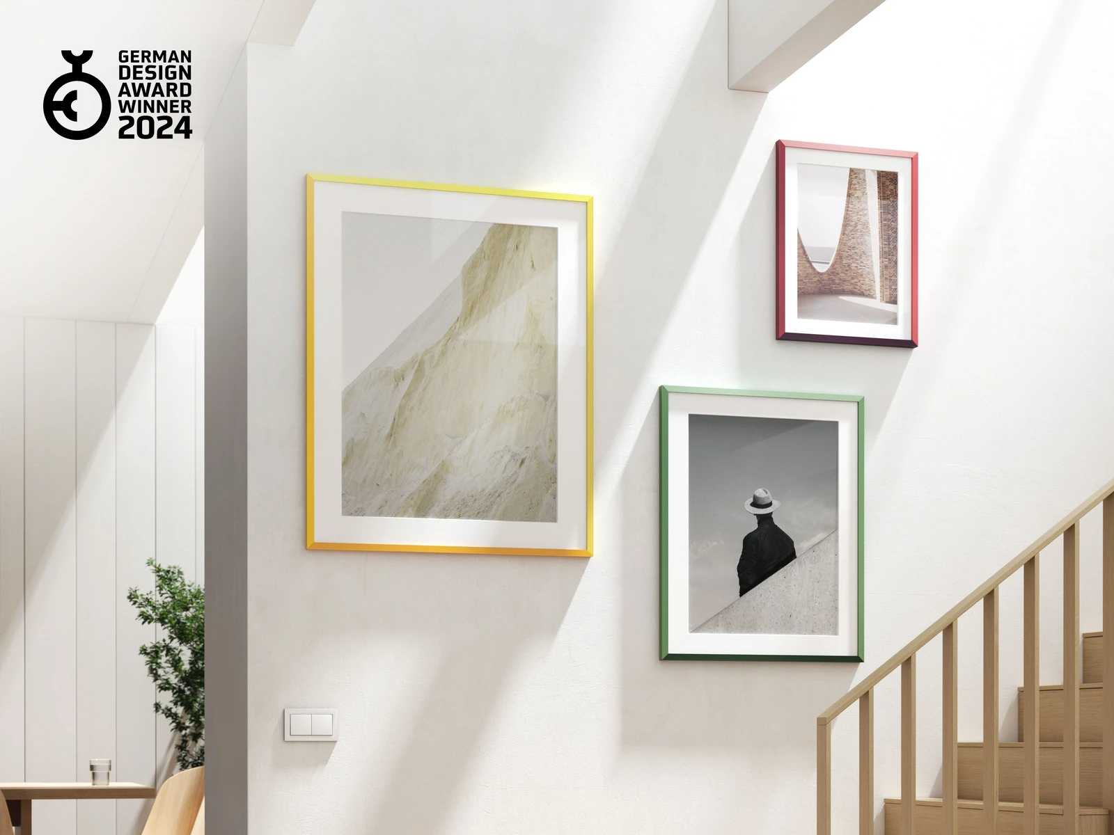 Three design edition frames, one of each color, hanging on a wall.