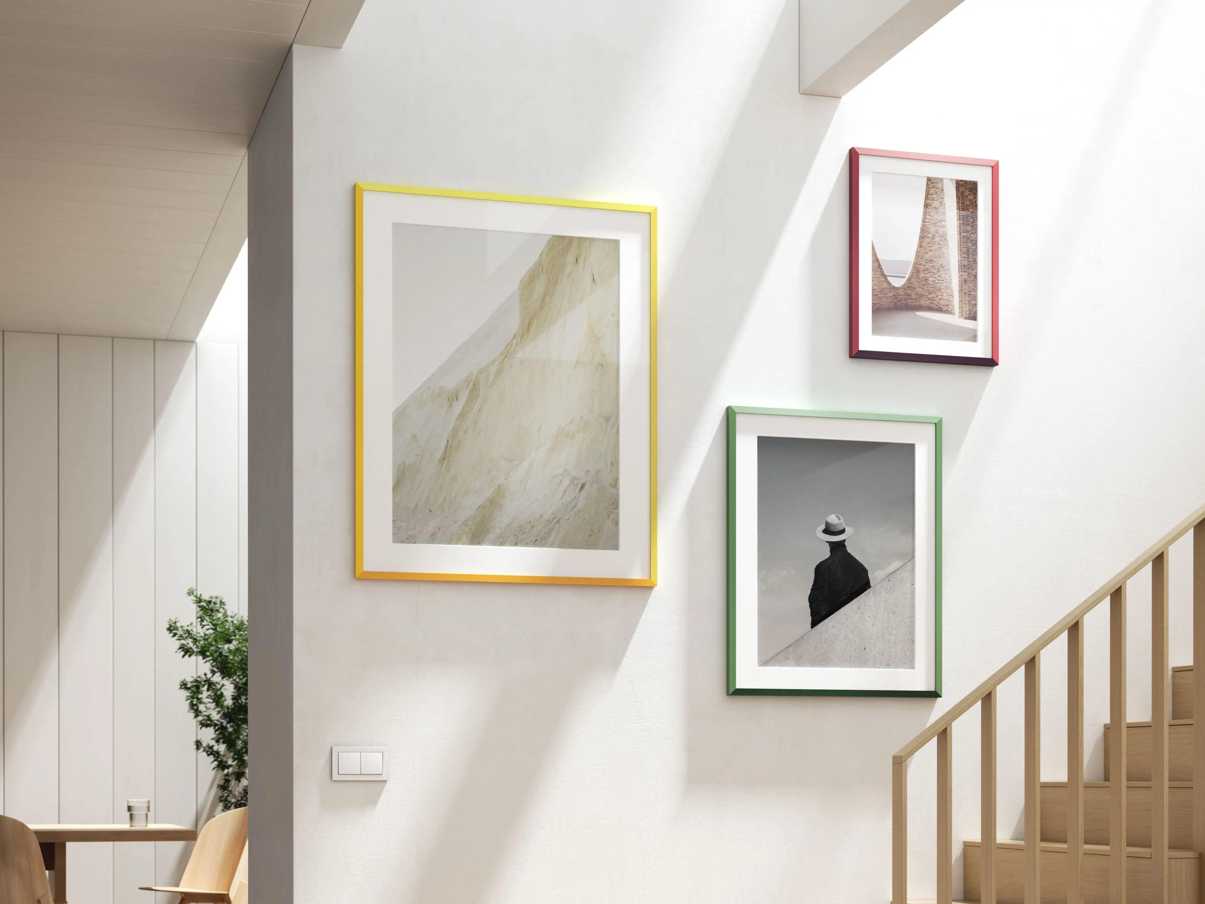 Three design edition frames, one of each color, hanging on a wall.