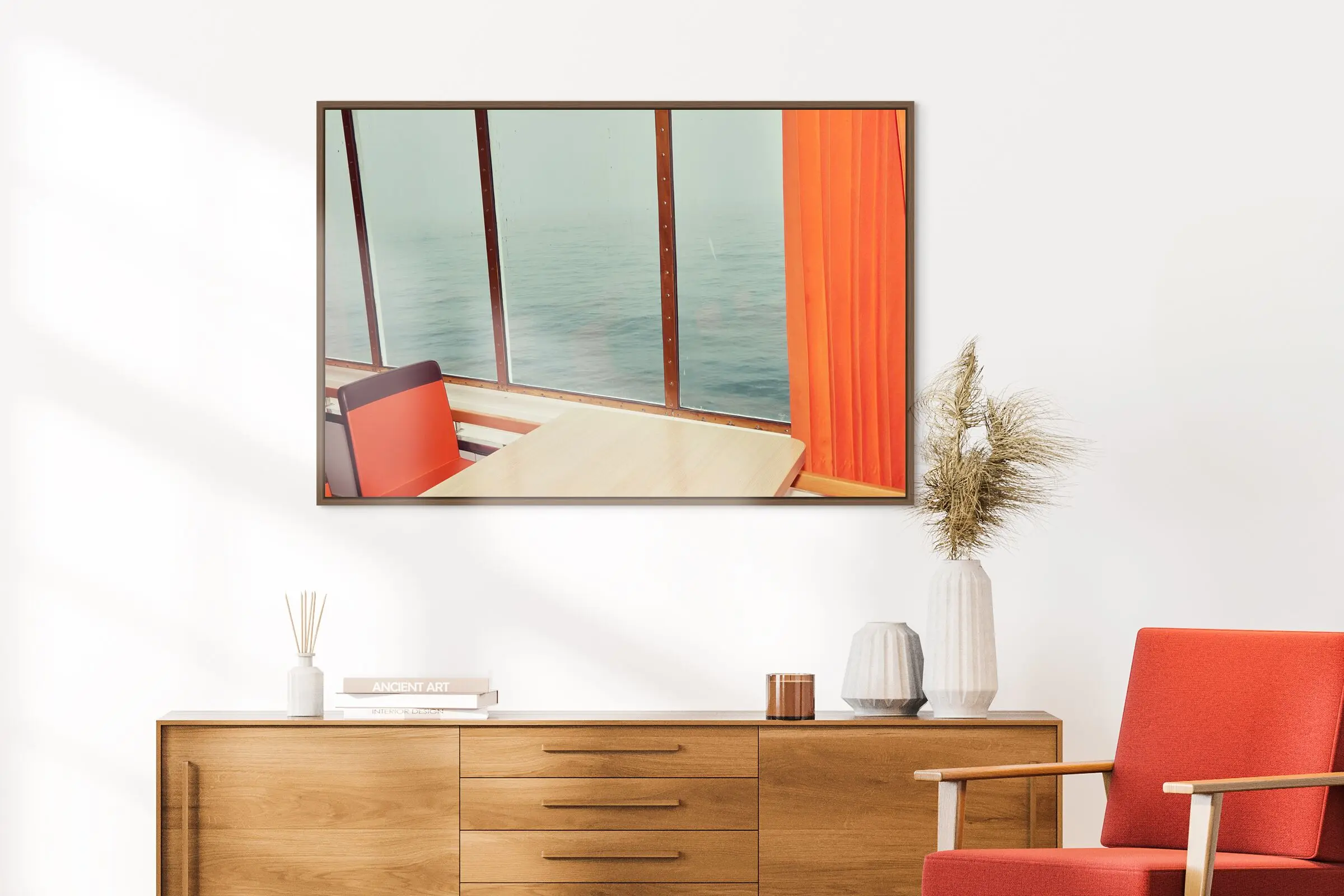 photo with red orange curtain and chair with large windows with water view.