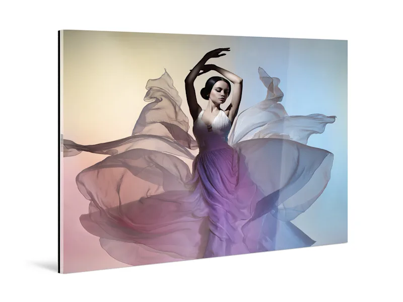 Dancer with fluttering dress as ultraHD metallic print behind acrylic glass, with ultraHD logo in the corner.