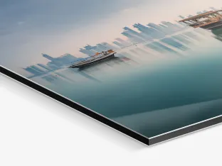 Close up of the image of three boats reflected on the calm sea surface, while in the background is a skyline on a Photo Print On Aluminum Backing.
