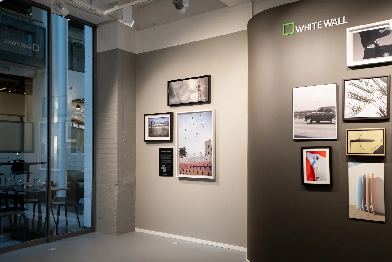 Gallery wall with WhiteWall logo and various framed photographs and works of art.