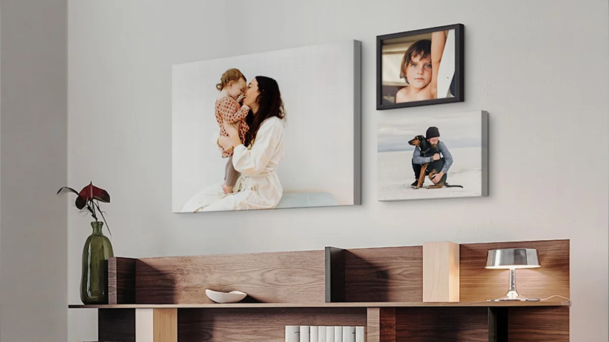 Drei Foto-Leinwände mit verschiedenen Motiven an einer Wand über einem Holzregal.