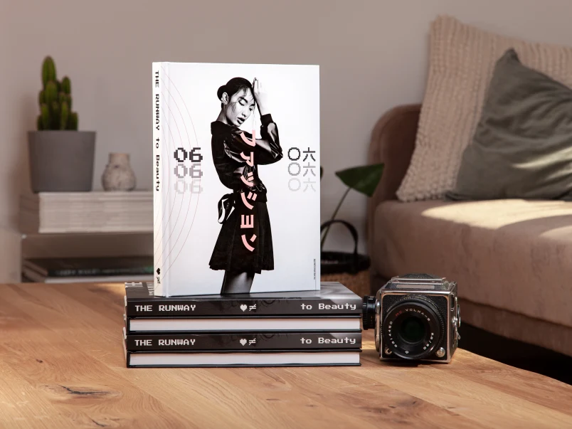 Libros Fotográficos apilados unos encima de otros en una mesa de salón, con una cámara al lado