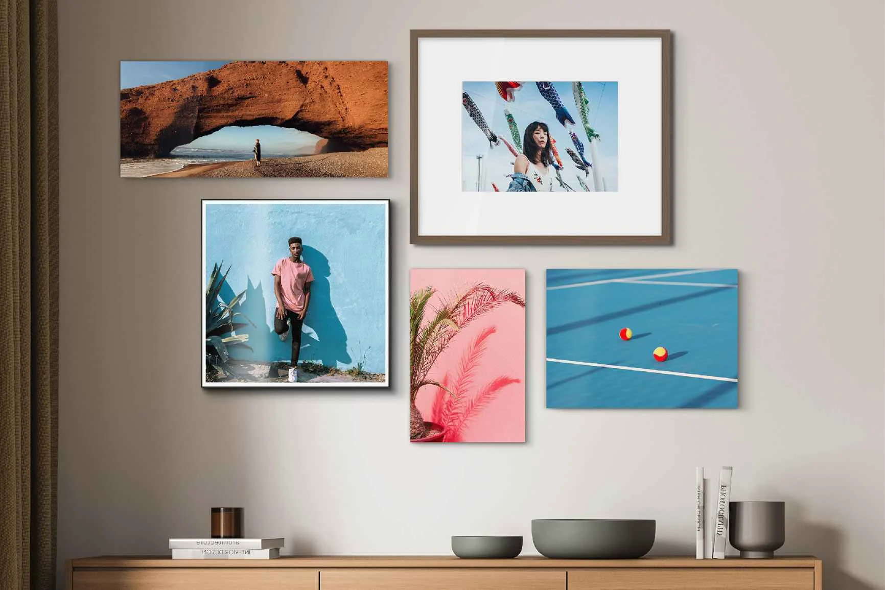 Parete con cinque foto incorniciate: un paesaggio, una donna, bandiere colorate con carpe, una pianta e un campo da tennis.