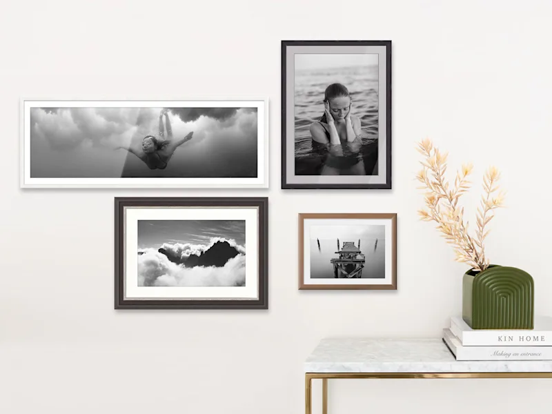 Several printed photos on baryta paper hanging on a wall.