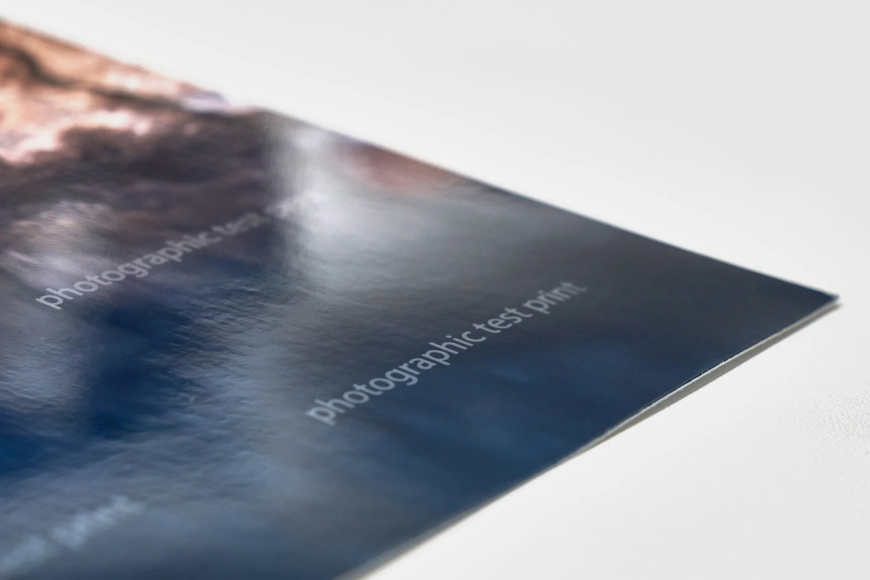 Nahaufnahme eines glänzenden Testfotodrucks mit sichtbarem Wasserzeichen.