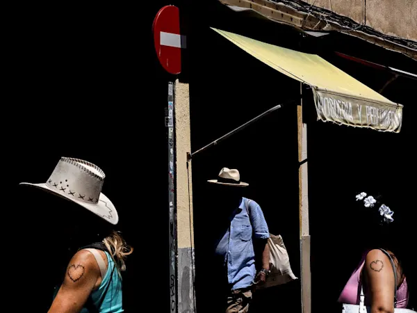 Javier Arcenillas – STREET CARTOGRAPHY: Kontrastreiches Bild mit Silhouetten, einem roten Verkehrsschild und gelber Markise vor tiefem Schwarz.