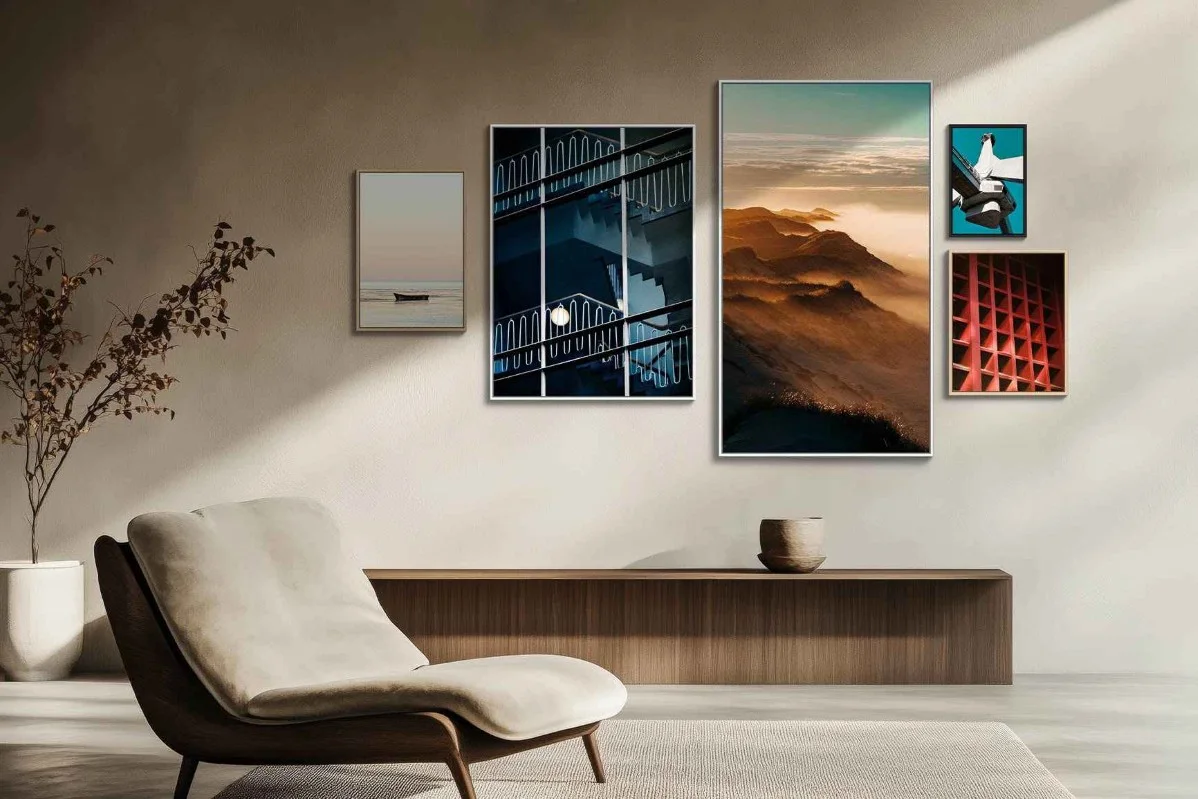 Soggiorno con poltrona moderna, credenza e cinque quadri incorniciati alle pareti, tra cui paesaggi e motivi astratti.