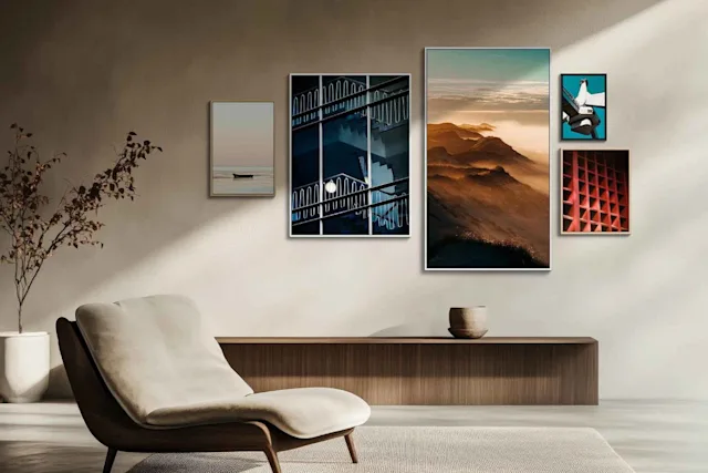 Soggiorno con poltrona moderna, credenza e cinque quadri incorniciati alle pareti, tra cui paesaggi e motivi astratti.