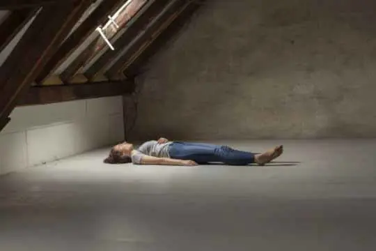 Woman laying in an empty attic - Photo by Irina Bittner.