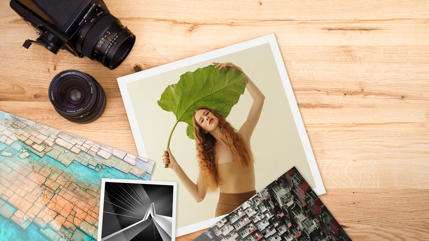 various photo paper options lying on a wooden surface.