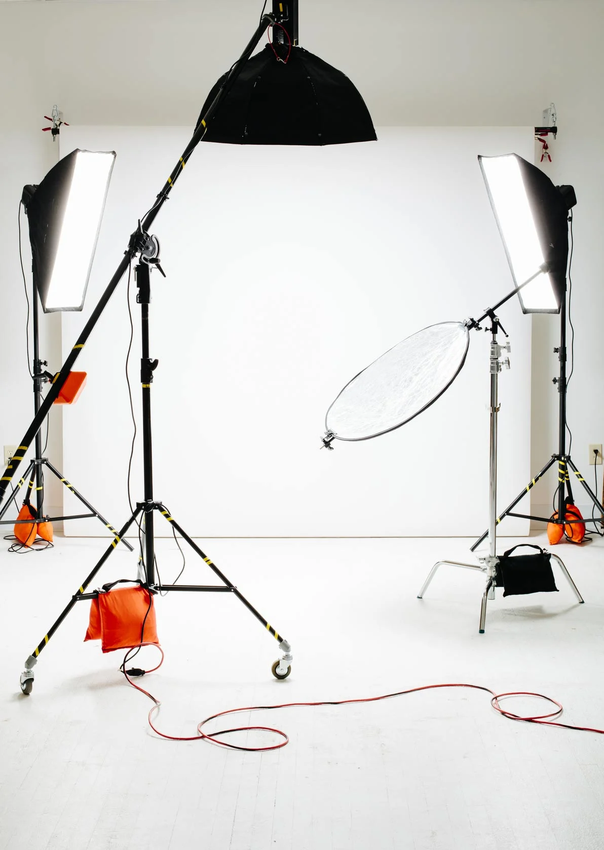 Photo studio with three studio lights and white background.