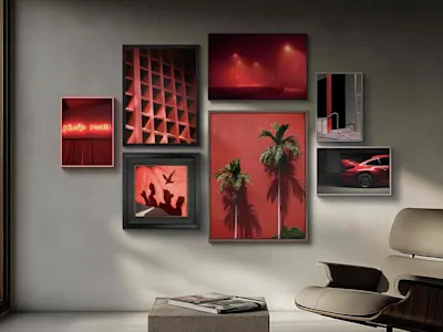 Una parete-galleria di foto incorniciate a tema rosso, tra cui palme, un’insegna al neon, un’auto rossa e architettura, sopra una sedia moderna.