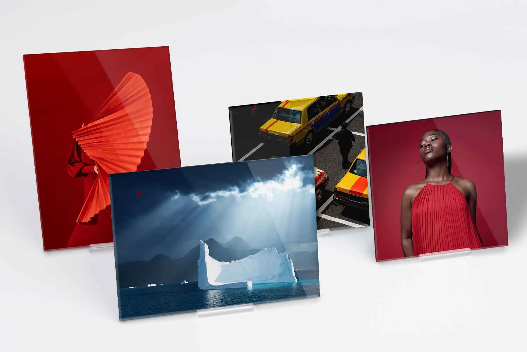 Vier Acrylglas-Fotoaufsteller zeigen verschiedene Motive.