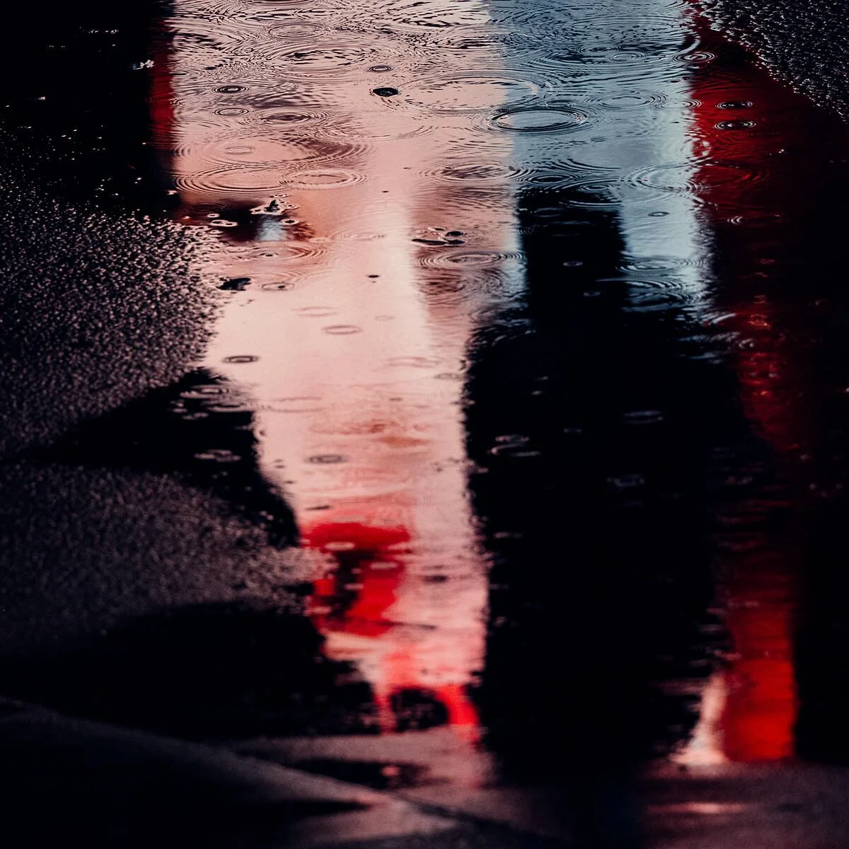 Verzerrtes Gesicht mit roten Lippen, reflektiert auf einer nassen Oberfläche.