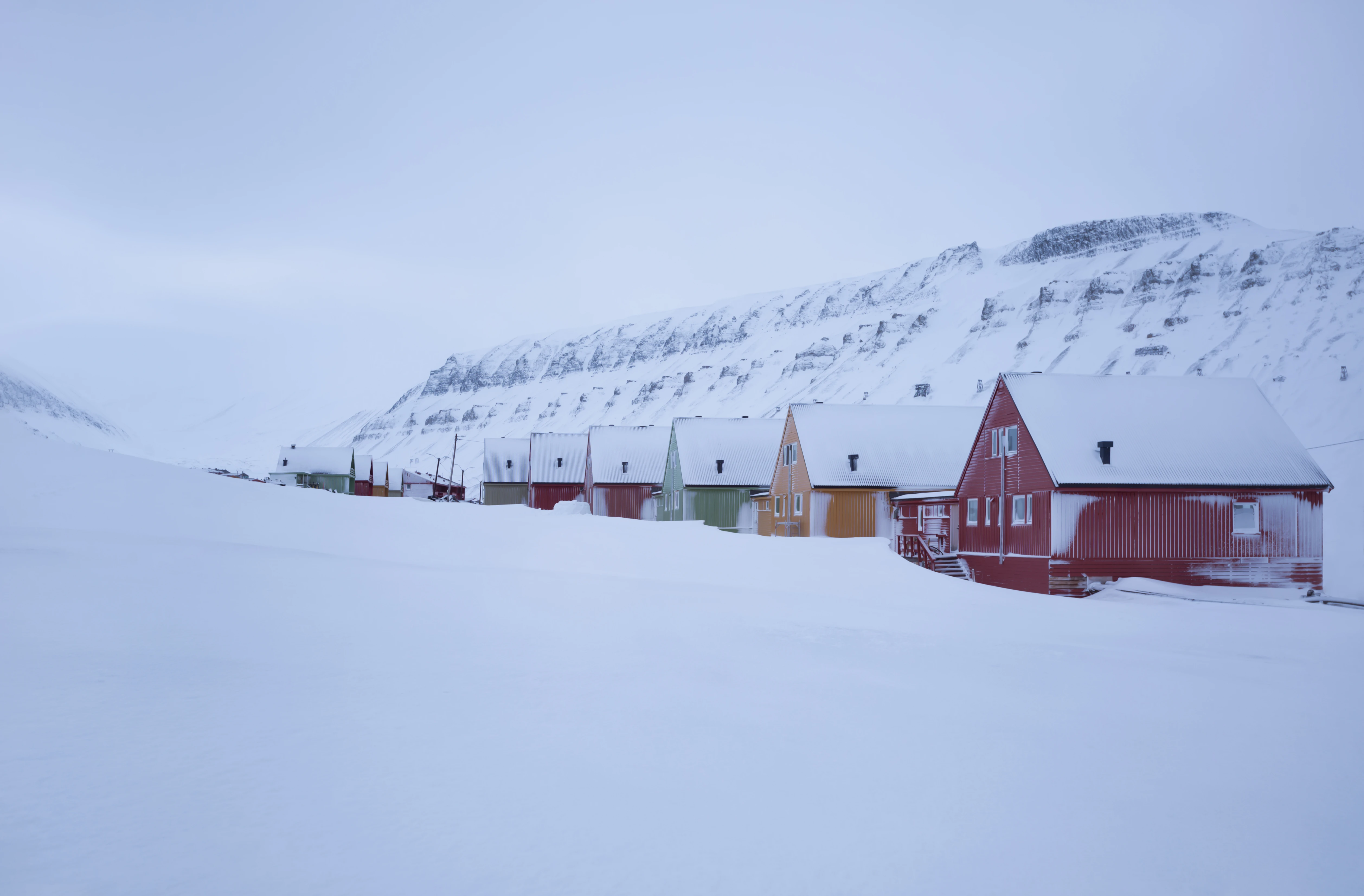 snow covered houses in a mountain landscape.