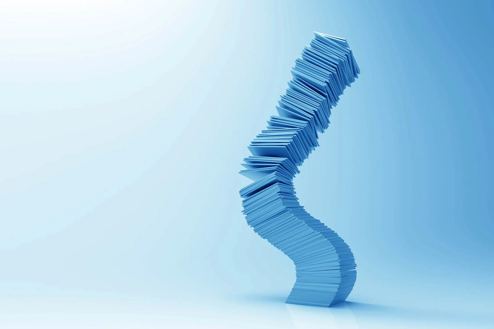 Ein hoher, geschwungener Stapel aus blauen rechteckigen Blättern vor hellem Hintergrund.