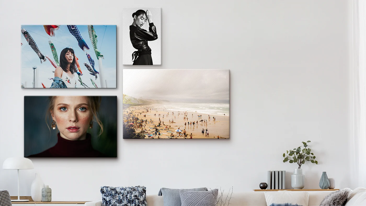 three portrait photos and a beach photo as canvas prints on a wall.