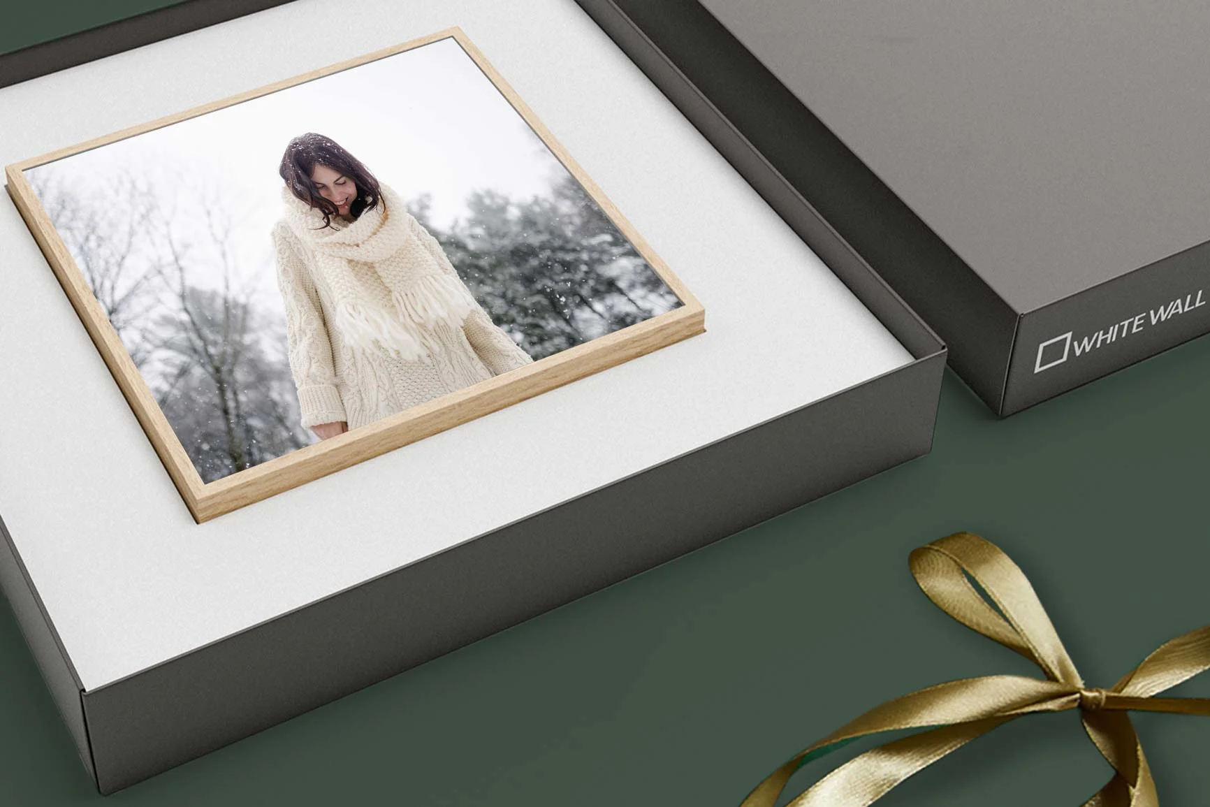 Foto einer Person in weißem Schal und Mantel vor winterlicher Waldkulisse, liegend ArtBox.