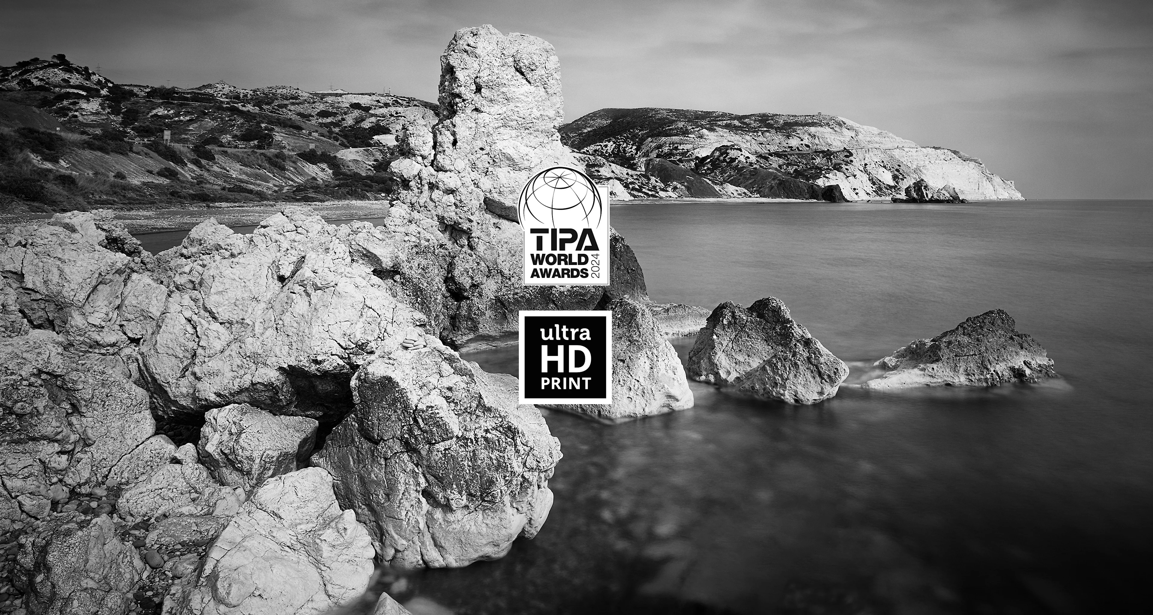 Rocks in the water in front of a mountain landscape in black and white and our ultraHD quality.