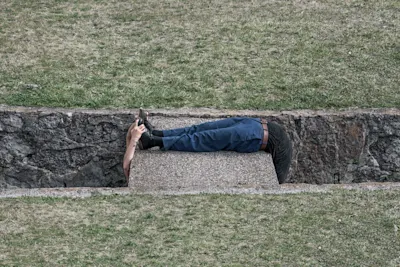 abstract photo of a person grabbing their own feet who is wrapped around a block of cement.