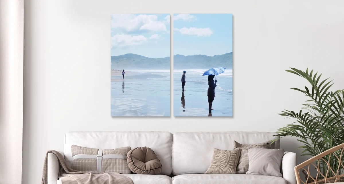 People standing on a beach in the sea. The whole picture is divided into two parts hanging horizontally on the wall. 